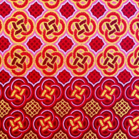 Tissu Wax pailleté rouge orangé imprimé Celte détail bordure